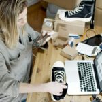 Pakistani IT professional setting up an e‑commerce website on a laptop in a modern workspace