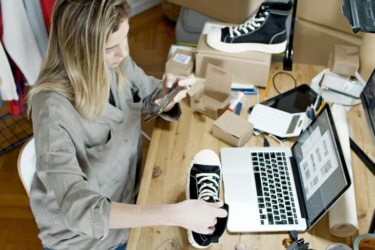Pakistani IT professional setting up an e‑commerce website on a laptop in a modern workspace